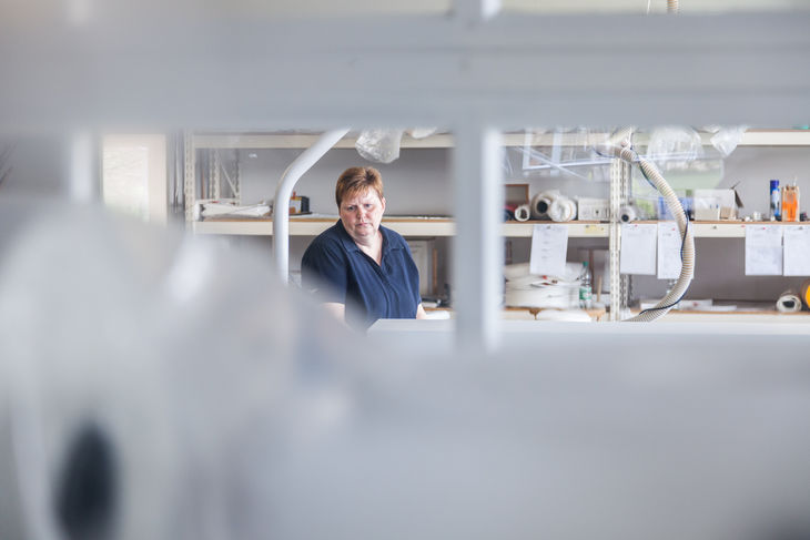 Mitarbeiter in Produktionshalle für Industriefilter, Arbeitsumgebung mit Maschinen und Materialien Mitarbeiter in Produktionshalle für Industriefilter, Arbeitsumgebung mit Maschinen und Materialien