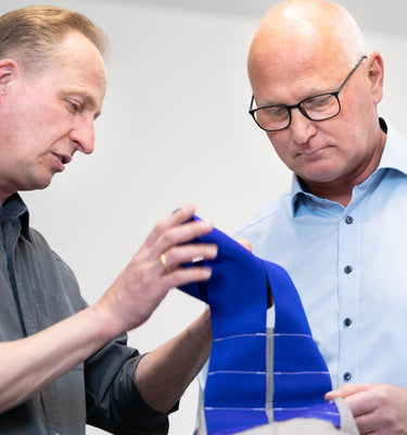 Beratung Filtertechnik Fachliche Beratung zwei Personen prüfen blaues Gurtband mit weißen Nähten im Innenraum